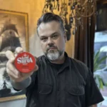 Modelo com barba segurando a pomada Lord Shiva Power Matte 50g em destaque para a câmera.