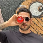 Modelo masculino com estilo urbano segurando a pomada Lord Shiva Power Matte.