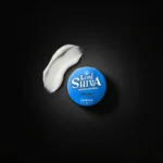 Amostra da textura branca e pastosa da pomada Strong Matte ao lado do produto.