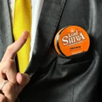 Pomada efeito molhado Power Brilho Apoiada no bolso do palitó mostrando o tamanho e a portabilidade do produto