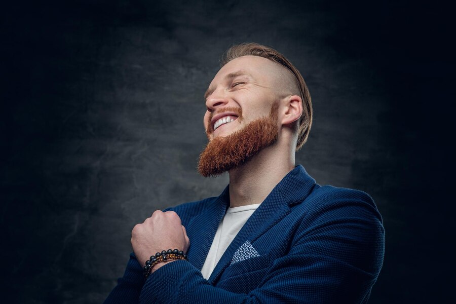 portrait-bearded-redhead-hipster-male-dressed-blue-jacket-grey-background_613910-11969
